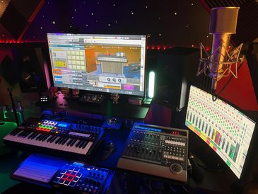 A vibrant music production studio with keyboards, mixers, and dual monitors.