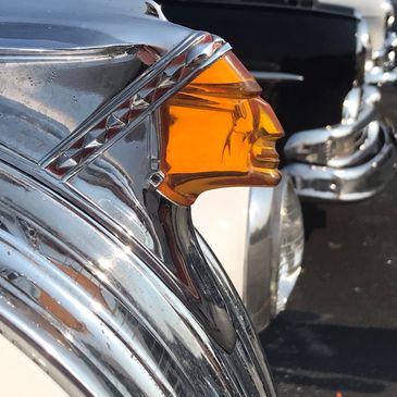 Close-up of a vintage car hood ornament shaped like a Native American figure.