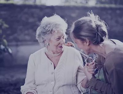 Elder being greeted by a young woman
