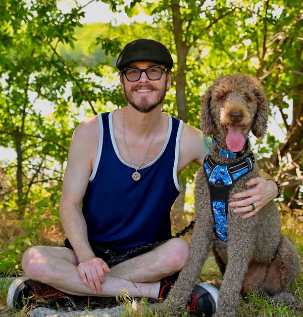 Man sitting outdoors with his dog.