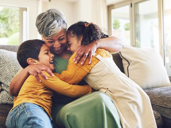 Grandmother embracing her two grandchildren.