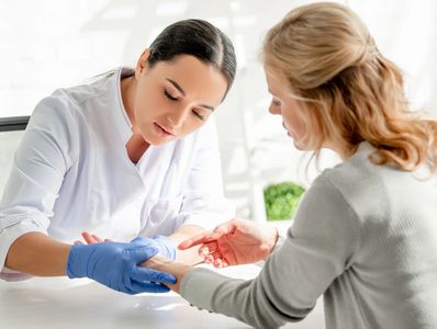 "A healthcare professional examines a patient's wrist while explaining a procedure"