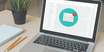 Open laptop showing email inbox and new message received