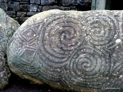 Carved Neolithic triple spiral designs on rock New Grange Ireland.