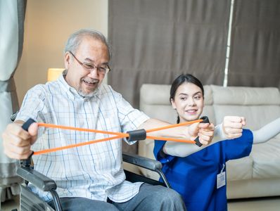 Smiling senior man doing resistance band exercises with therapist.