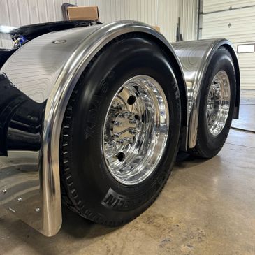 Polished set of drive tires and fenders on a Kenworth