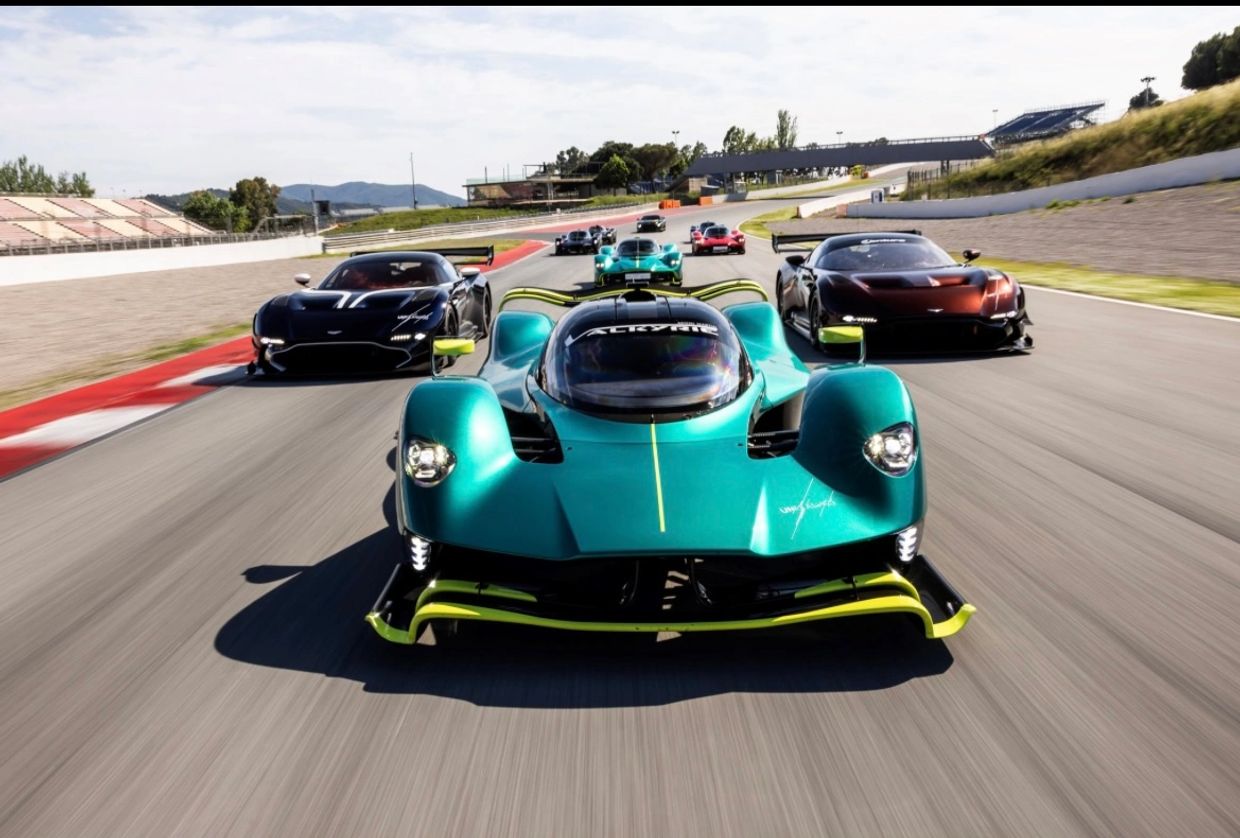 High-speed race with exotic cars on a track.