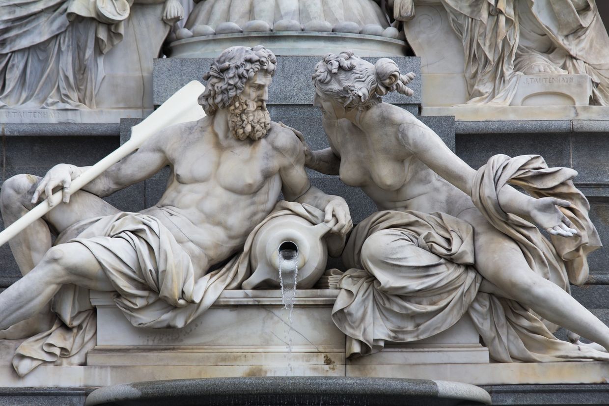 Marble statue of a man and woman by a fountain.