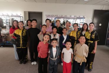 Group photo of children and adults in martial arts attire.