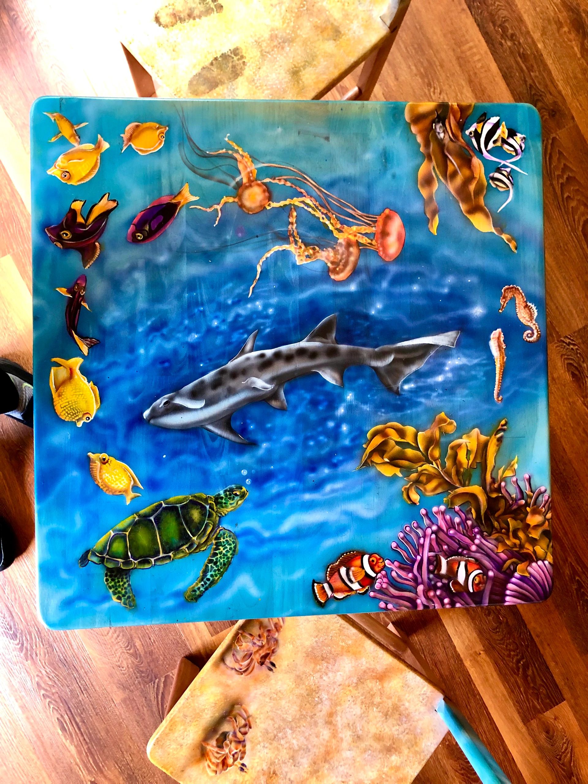 Colorful underwater scene painted on a table with sea creatures.