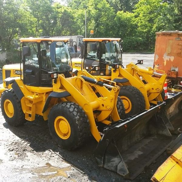 Two yellow front loader construction vehicles parked side by side.