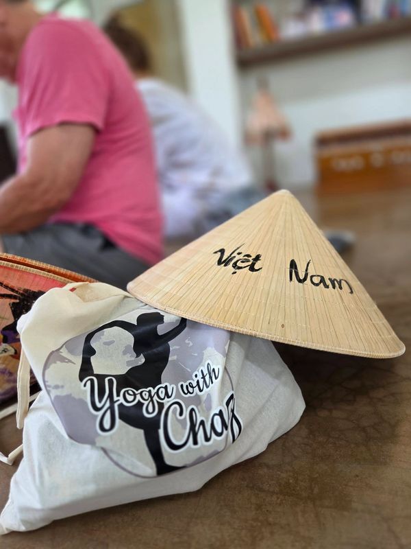 Vietnamese conical hat next to a yoga bag labeled 'Yoga with Chaz.'