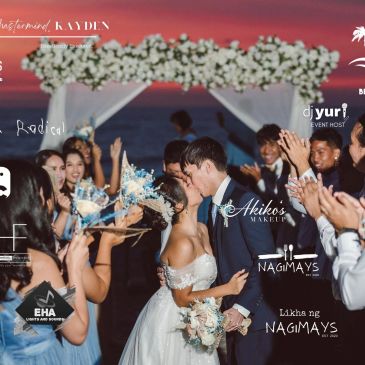 Wedding couple kissing surrounded by cheering guests.