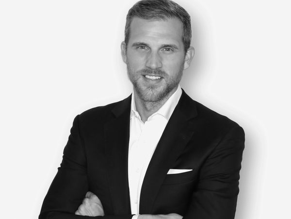 Confident man in suit with arms crossed.