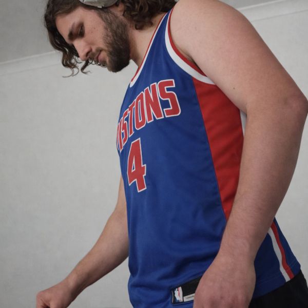 Man wearing a blue Pistons basketball jersey with number 4.