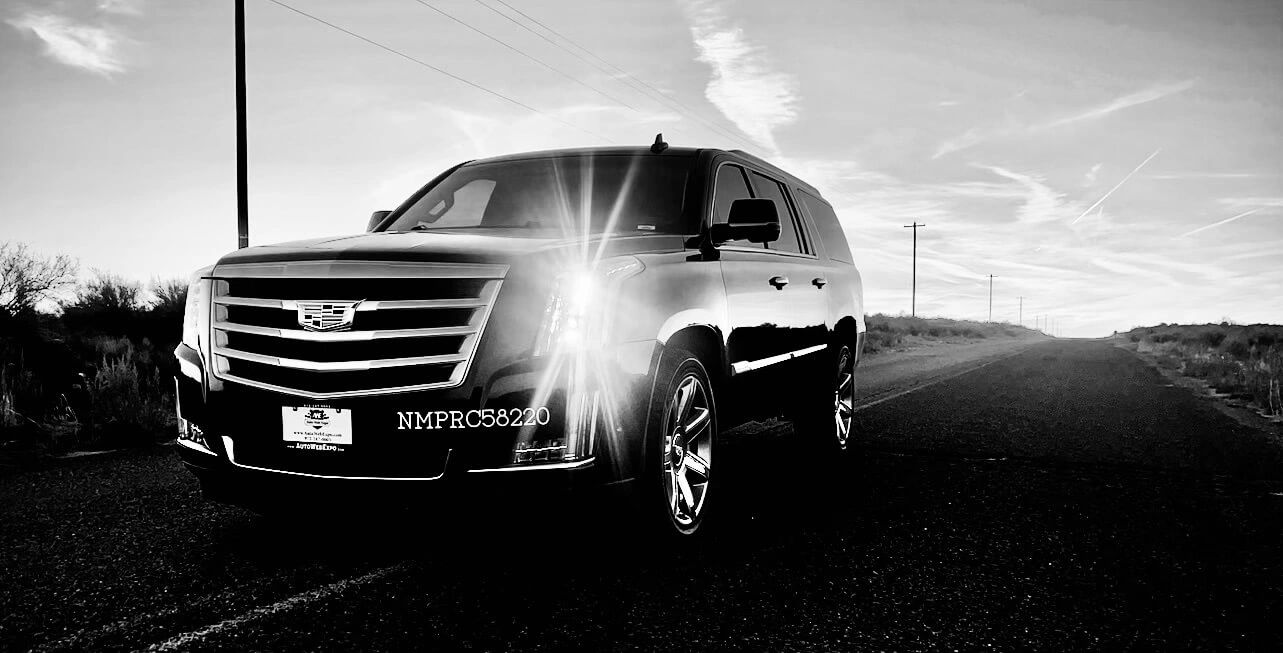 A black and white picture of a black Cadillac Escalade 
