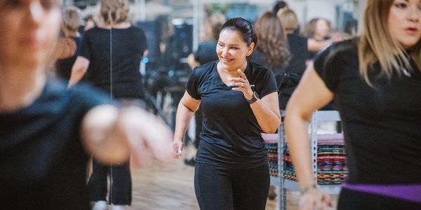 Women enjoying a group fitness class in a mirrored studio.