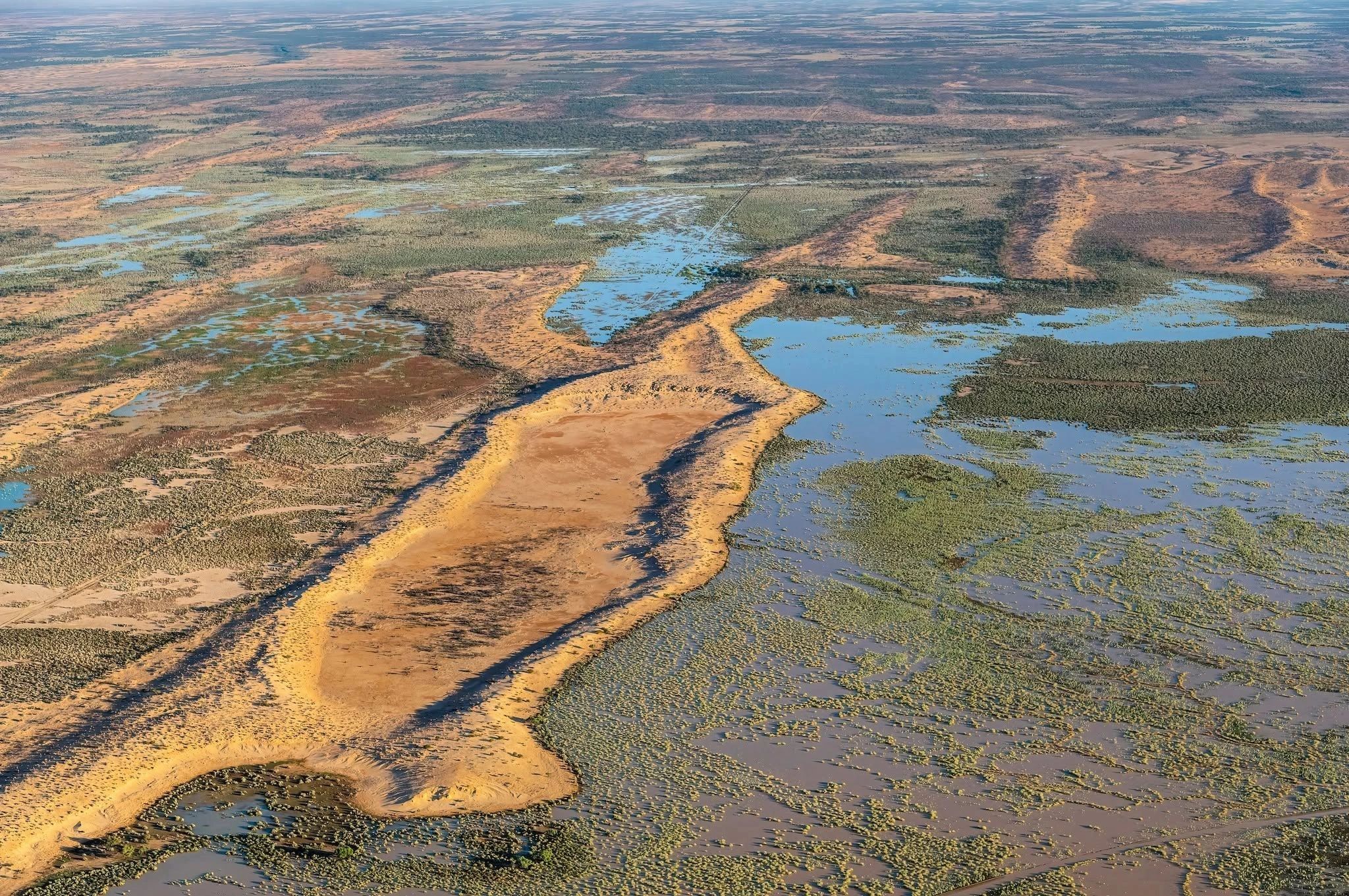 Aerial view of a flooded desert landscape with water and vegetation.