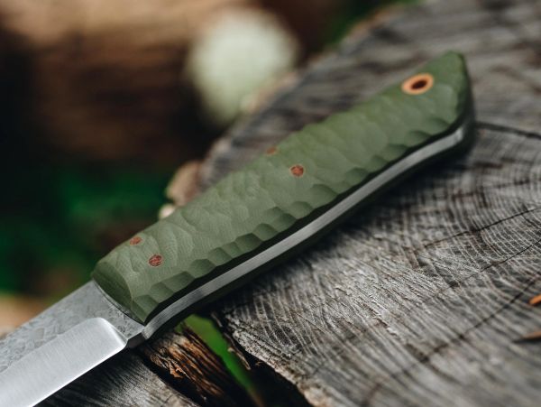 Knife with green textured handle on wood surface.