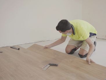 Man installing new timber laminated wooden floor, home improvement, house renovation project concept