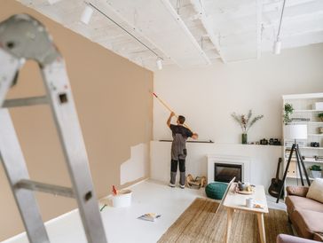 Man painting living room wall during apartment renovation