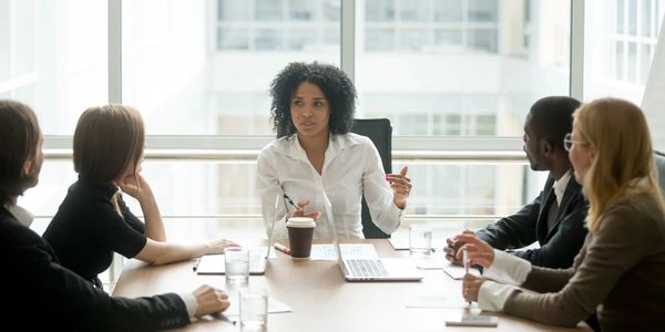 Woman leading a business meeting with attentive colleagues around a conference table.