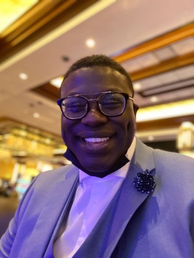 Smiling man in glasses and suit jacket.
