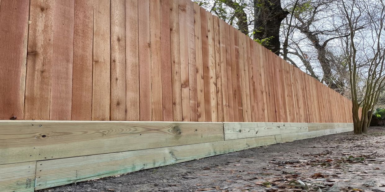 Newly built wooden fence with fresh planks and a natural setting.