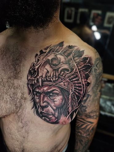Custom black and grey chest tattoo featuring a Native American warrior