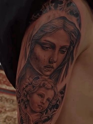 Black and grey realism tattoo of Virgin Mary and cherub on shoulder in Salem NH.