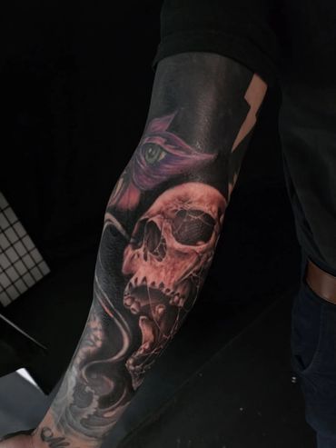 Custom blackout sleeve tattoo cover-up featuring a high-contrast skull on the forearm, mayhem salem