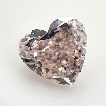 Heart-shaped faceted gemstone with a pinkish hue.