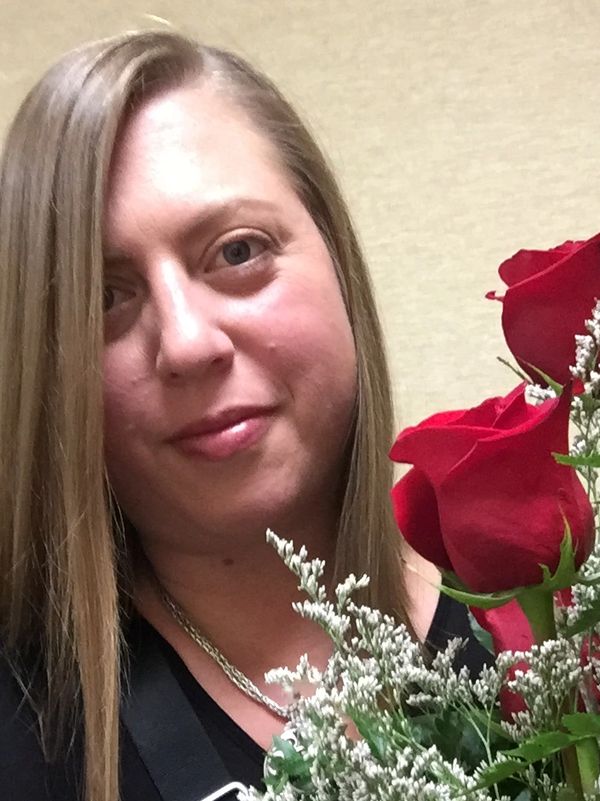 Photo of the studio founder, Lauren Klouda, holding red roses.