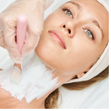 Woman receiving a white facial mask treatment on her neck.