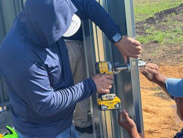Installing door handle on well shed door for water well building
