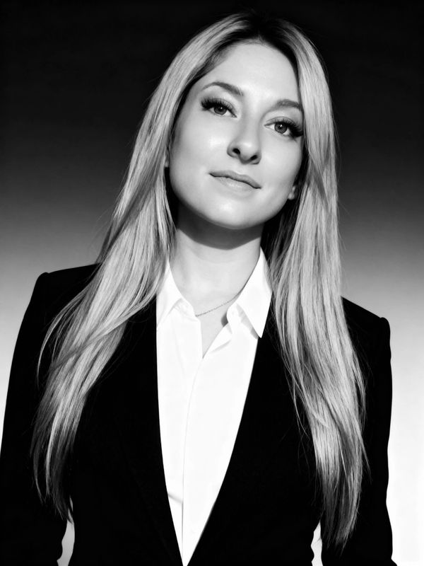Professional black and white portrait of a confident woman in a suit.