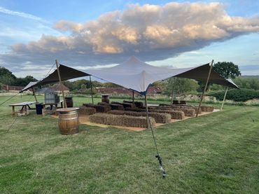 Outdoor party setup with stretch tent and seating arrangements