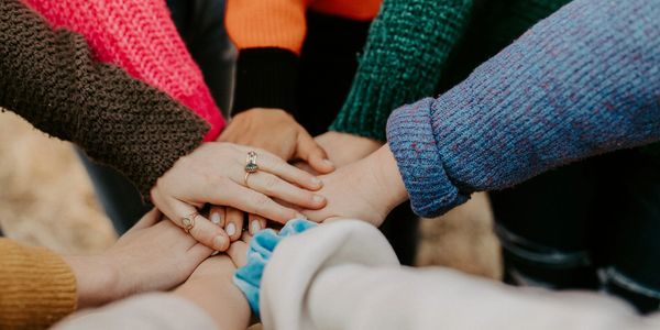 A group of hands stacked together in unity.