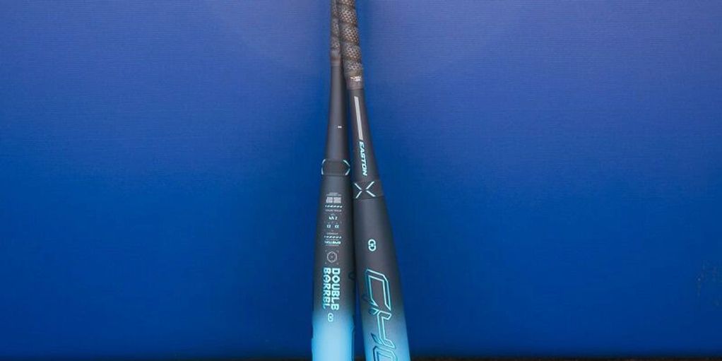 Two baseball bats standing against a blue background.