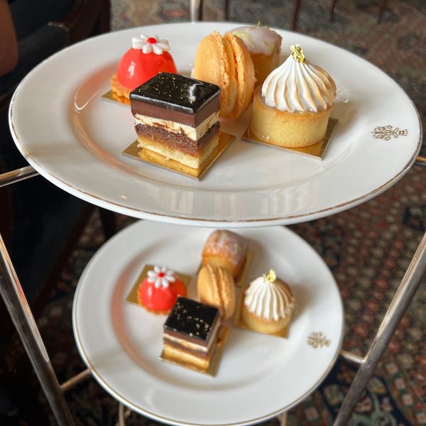 Assorted elegant mini desserts on two white plates.