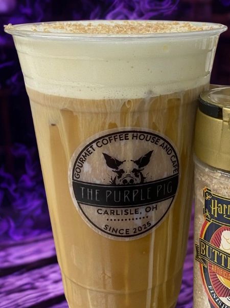Iced coffee from The Purple Pig with creamy foam on top.