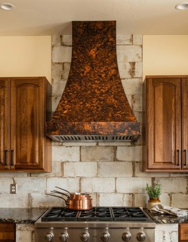 Custom hammered copper kitchen range hood by Tin Works with rich patina finish