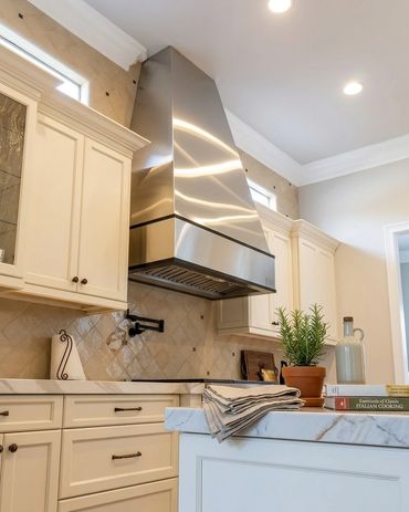Custom stainless steel kitchen range hood by Tin Works in luxury residential kitchen