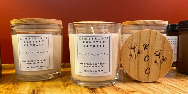 Hand-poured sandalwood soy candles from Kimberly's Country Candles on a rustic wooden shelf.