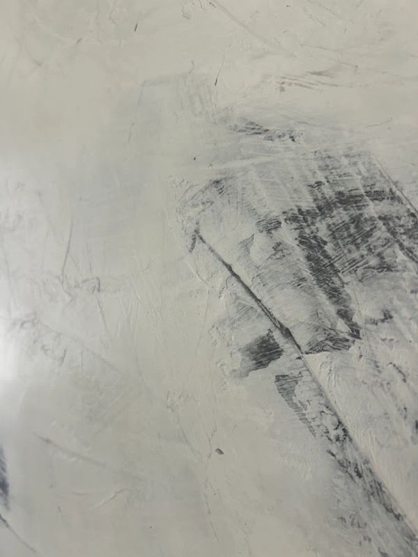Textura gris con marcas oscuras y rayas.