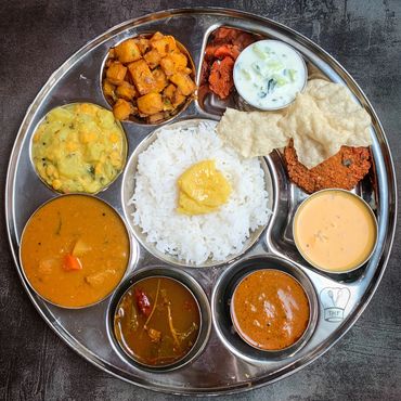 South Indian Thali featuring a variety of delicious dishes like rice, sambar, rasam,poriyal etc..