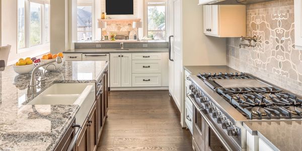 Quartz countertop in stylish galley kitchen with engineered hardwood flooring.