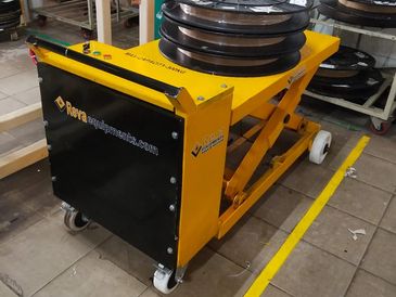 Yellow and black hydraulic scissor lift table with wheels.