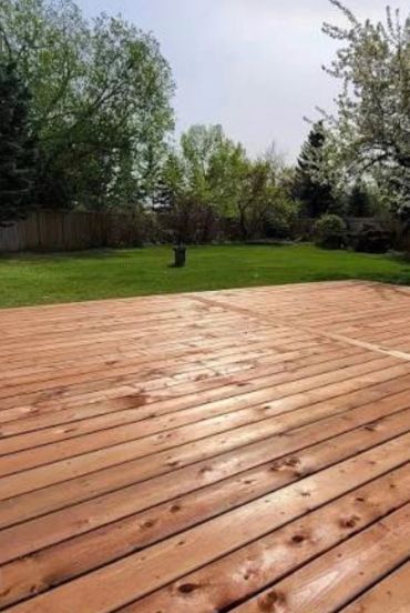 Custom wood deck construction for a residential backyard by Blue Collar Vertical Industries.