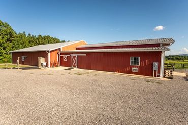 A large red barn with white trim under a clear blue sky.